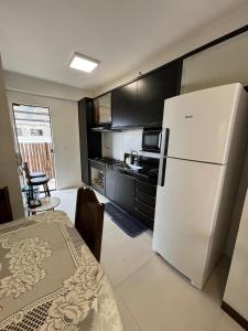 a kitchen with a white refrigerator and a table at villa privilege ap 01 in Marau