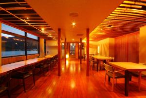 un restaurante con mesas y sillas en una habitación en Ginka, en Toyooka