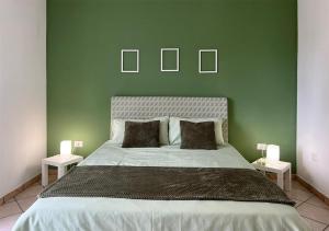 1 dormitorio verde con 1 cama grande y 2 lámparas en Rosemary s House Napoli City Apartment con Parcheggio, en Nápoles