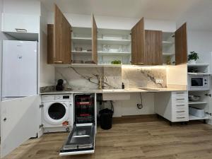 una cocina con lavadora y secadora bajo una barra en La fonda de Olympia, en Valencia 28 fotos más