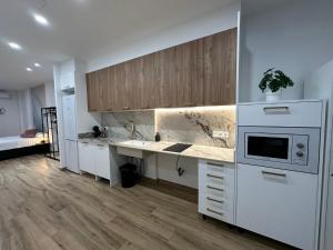 Una cocina con gabinetes blancos y encimera. en La fonda de Olympia, en Valencia
