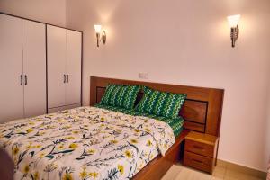 a bedroom with a bed with green pillows at SERENITY Flat3 in Pointe-Noire