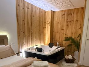 y baño con bañera en una pared de madera. en Vivienda Plaza Mayor, en León
