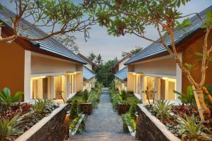 a path between two houses with plants at Askara Canggu Townhouse in Canggu