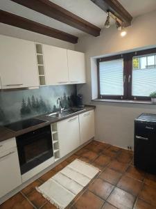 a kitchen with white cabinets and a sink at Ferienhaus am Mühlenberg in Schleiden