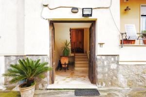 a hallway leading to a house with a door at Mythos House in SantʼAgata sui Due Golfi