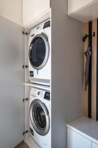 two washers and a dryer in a laundry room at Quality apartman in Tihany