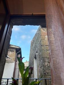 une fenêtre avec vue sur un bâtiment dans l'établissement Casetta privata nel corso, à Pitigliano