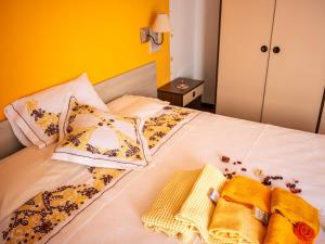 Una cama blanca con almohadas y toallas. en B&B La Vittoria, en Crone