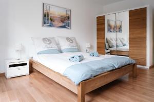 a bedroom with a large bed and a mirror at Sunny Maritime Apartment near Hannover central station in Hannover