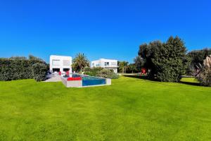 a green lawn with a swimming pool in a park at Villa VINNER - Monopoli in Monopoli