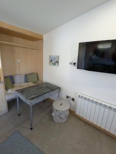 a room with a table and a tv on the wall at Modern Eco-Lodges near Findhorn Beach in Findhorn