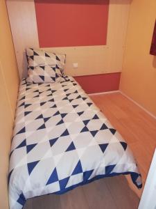 a bedroom with a bed with blue and white comforter at Mobil home la Salamandre in Vaour