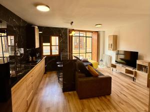 cocina y sala de estar con sofá y TV en Vivienda Plaza Mayor, en León