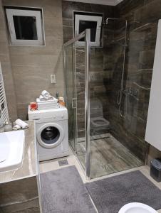 a bathroom with a shower and a washing machine at Lux Old Bridge in Mostar