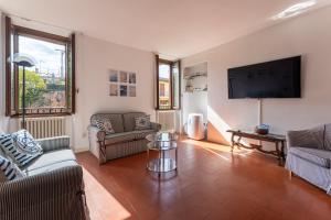 un salon avec un canapé et une télévision dans l'établissement Casa Preziosa - Salò, à Salò