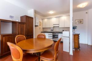 une cuisine avec une table et des chaises en bois dans une pièce dans l'établissement Casa Preziosa - Salò, à Salò