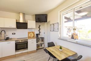 a kitchen with a wooden table and a dining room at LaraBella Salt fields view studio in Portorož
