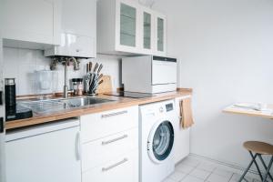 a kitchen with a washing machine and a sink at Sunny Maritime Apartment near Hannover central station in Hannover
