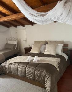 a bedroom with a bed with a mosquito net above it at Radici - La finestra sui Sassi in Matera
