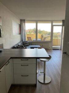 a kitchen with a table and a stool in a room at Oben in der 14 Etage in Braunlage