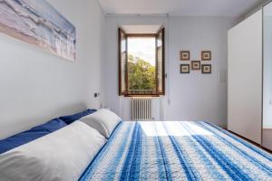 - une chambre avec un lit bleu et blanc et une fenêtre dans l'établissement Casa Preziosa - Salò, à Salò