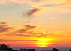 una puesta de sol con el sol en el cielo en Acanthus Oia-Private Jacuzzi Suites, en Oia