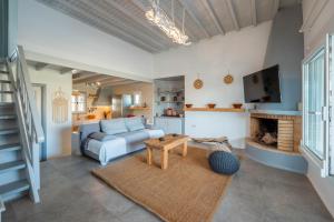Una sala de estar con un sofá y una chimenea. en Blue Cove Maisonette at Ftelia beach, SeaView, en Mykonos ciudad
