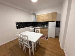 a kitchen with a white table and chairs in it at Klito`s Home in Krujë