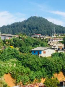 eine kleine Stadt auf einem Hügel mit einem Berg in der Unterkunft Sams Cottage in Nuwara Eliya