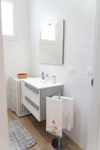 a white bathroom with a sink and a mirror at Corte Maria in Castri di Lecce +30 photos