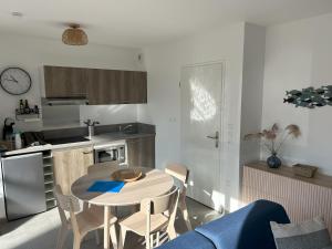a kitchen with a table and chairs in a room at Studio Le Béryl in Le Crotoy