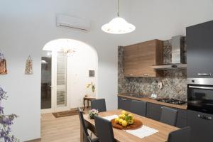 a kitchen and dining room with a table and chairs at Corte Maria in Castri di Lecce