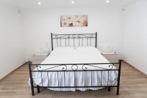 a bed with a metal frame in a bedroom at Corte Maria in Castri di Lecce