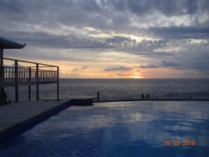 a swimming pool in front of the ocean with the sunset at Cliff Park Lembongan in Nusa Lembongan