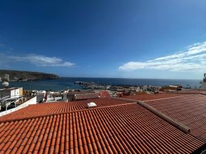 un techo de baldosas rojas con el océano en el fondo en Vista Mar y piscina climatizada, en Arona