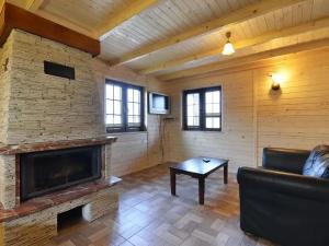 Una sala de estar con un sofá y una chimenea. en Domki w stylu góralskim Myśliwska 20, en Grzybowo
