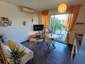 ein Wohnzimmer mit Tisch und Fernseher in der Unterkunft Apartment with pool in secure residence in Nizza