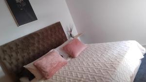 a bedroom with a bed with two pink pillows at Rim in Fez