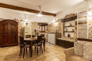 a kitchen with a table and chairs and a refrigerator at La Casa nella pietra suite Gargano in Vico del Gargano