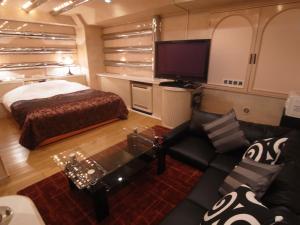 uma pequena sala de estar com uma cama e um sofá em Hotel Plage (Adult Only) em Yokohama