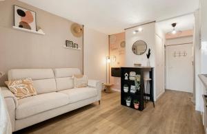 a living room with a white couch and a mirror at Studio La perle clim balcon parking privé in Cap d'Agde +3 photos
