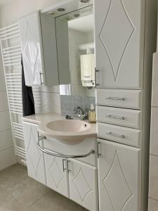 a white bathroom with a sink and a mirror at Ferienwohnung Ana in Langenlois +6 photos