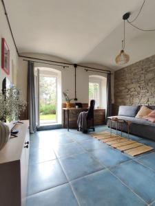 a living room with a couch and a stone wall at Apartamenty KDN Garden in Bielsko-Biała