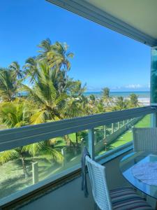 d'un balcon avec vue sur l'océan et les palmiers. dans l'établissement Pé na Areia e Vista ao Mar em Águas de Olivença Privê, à Olivença