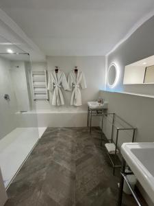 baño con toallas blancas colgadas en la pared en Les Grands Jardins Lodge, en Giverny 30 fotos más