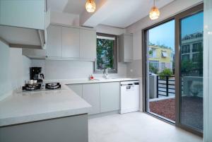 a kitchen with white appliances and a large window at Mama Saggio Home in Fethiye