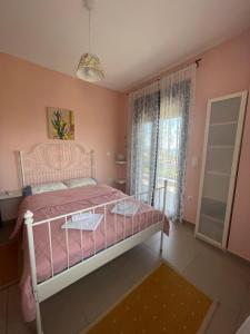 a bedroom with a pink bed and a window at Plaka Luxury Villa in Litochoro