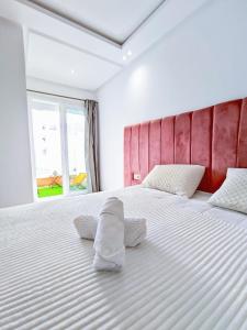 a bedroom with a large white bed with two pillows at Luxury Condo Mehdia Beach, Parking, Netflix, Games, High Speed Internet in Kenitra