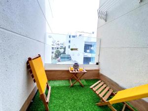 a balcony with a table and chairs and a window at Luxury Condo Mehdia Beach, Parking, Netflix, Games, High Speed Internet in Kenitra